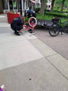 Shaker Square officer helping child with bike repair