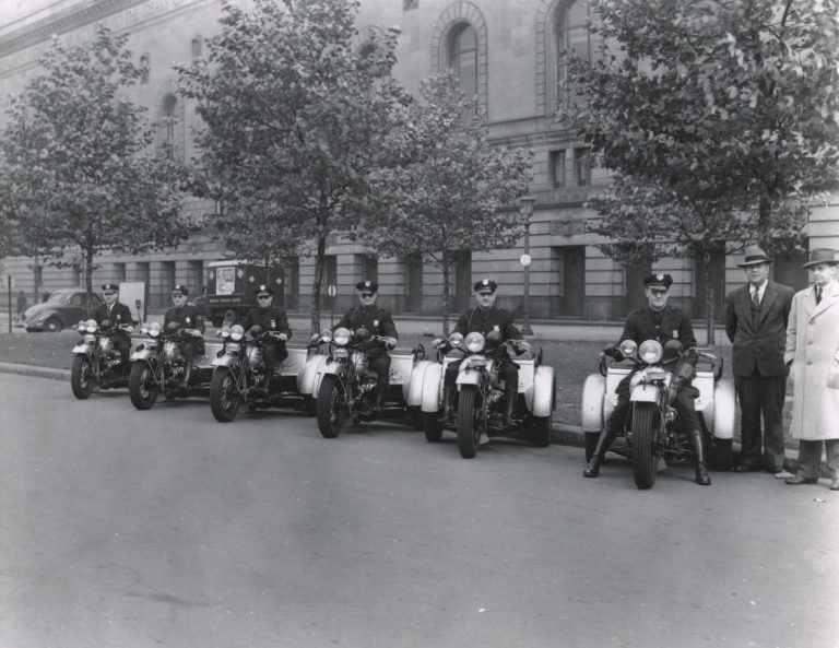 A photo of Eliot Ness inspecting a fleet of Harley-Davidson Servicars courtesy of the Cleveland Police Museum