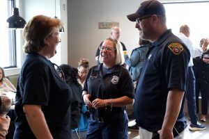 Officers and community members chat in small groups at the First District Coffee with a Cop event.
