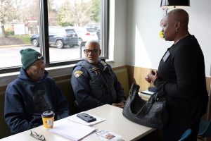 Community members talk with Cleveland Police officers at a booth during the Coffee with a Cop event.