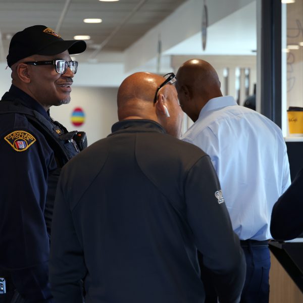 A Cleveland Police officer laughs while engaging with attendees in line at McDonald’s.