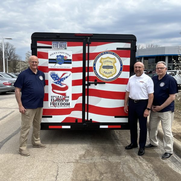 Group photo at the rear of the trailer with all supporting logos visible, including CPF and Flags of Freedom; Bob Guttu and Rick DeChant are pictured.