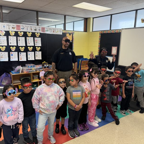 Officers Lavender and Melendez pose with a classroom of students wearing playful sunglasses during a visit to Scranton Elementary.