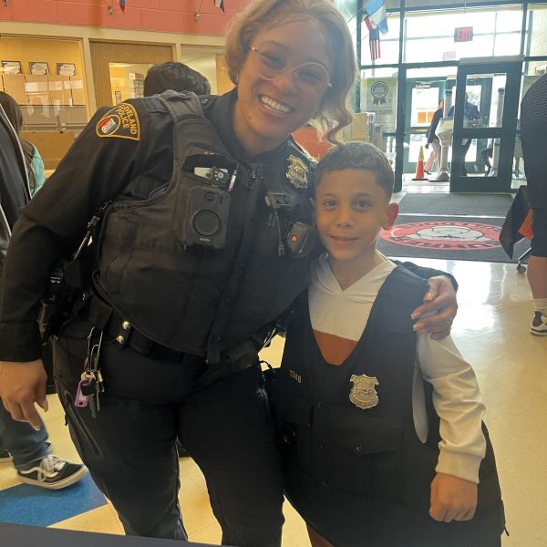 Officer Simpson smiles with a young student wearing a CPD vest at Buhrer Elementary