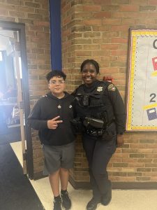 Officer Lavender stands smiling with a middle school student in the hallway at Scranton Elementary.