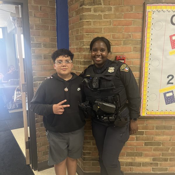 Officer Lavender stands smiling with a middle school student in the hallway at Scranton Elementary.
