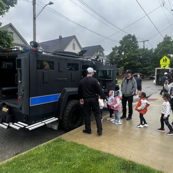 Children line up with parents and officers to explore a Cleveland SWAT vehicle outside Waverly Elementary.