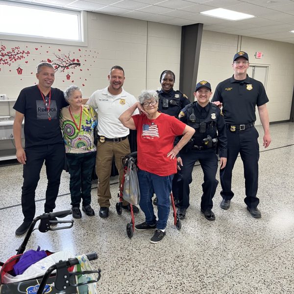 District 2 officers pose with smiling senior participants following the breakfast and CPOM presentation.