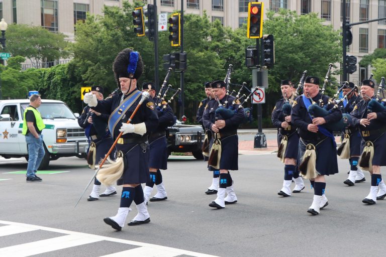 Cleveland Police Pipes and Drums march in formation along a city street during the NCLEES Memorial March