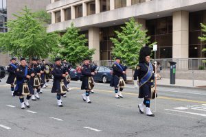 Cleveland Police Pipes and Drums march in formation along a city street during the NCLEES Memorial March