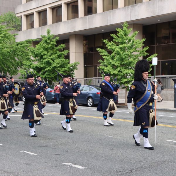 Cleveland Police Pipes and Drums march in formation along a city street during the NCLEES Memorial March