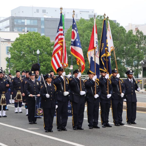 Cleveland Division of Police Honor Guard marches in formation carrying flags from Ohio, Cleveland, and allied agencies