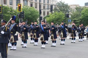 Cleveland Police Pipes and Drums continue through the intersection with pipers and drummers mid-performance