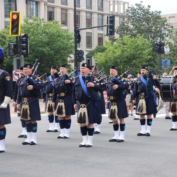 Cleveland Police Pipes and Drums continue through the intersection with pipers and drummers mid-performance