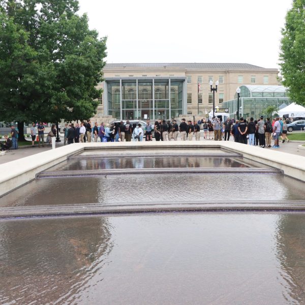 Crowd gathers near a reflecting pool outside the National Law Enforcement Museum during National Police Week