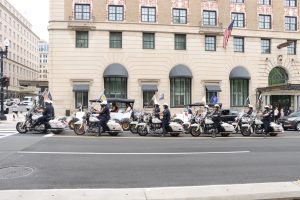 Motorcycle officers ride in formation during a memorial procession