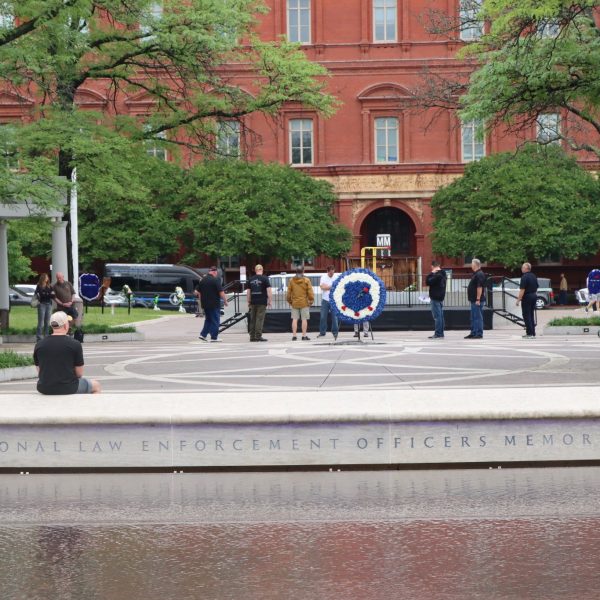 Visitors sit and reflect at the edge of the National Law Enforcement Officers Memorial fountain