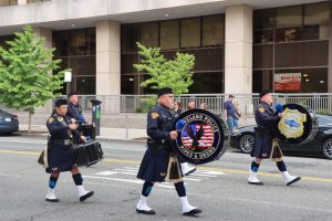 Drumline and pipers from the Cleveland Police Pipes and Drums continue down a city street